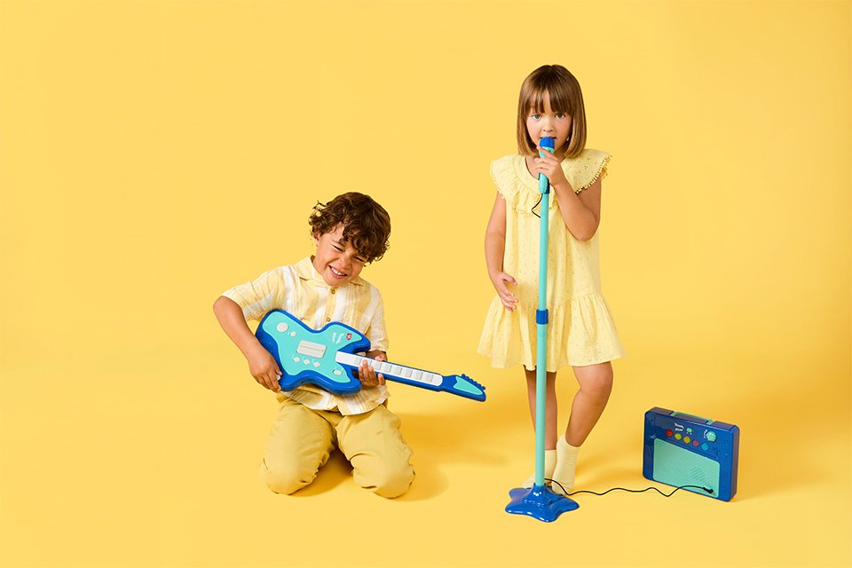 Two kids using Chad Valley's musical toys to put up a performance.